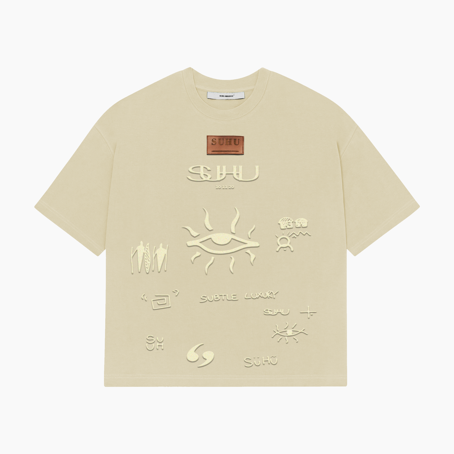 A beige SUHU t-shirt with various text and symbol embossments on the front, featuring the puff print SUHU symbols.
